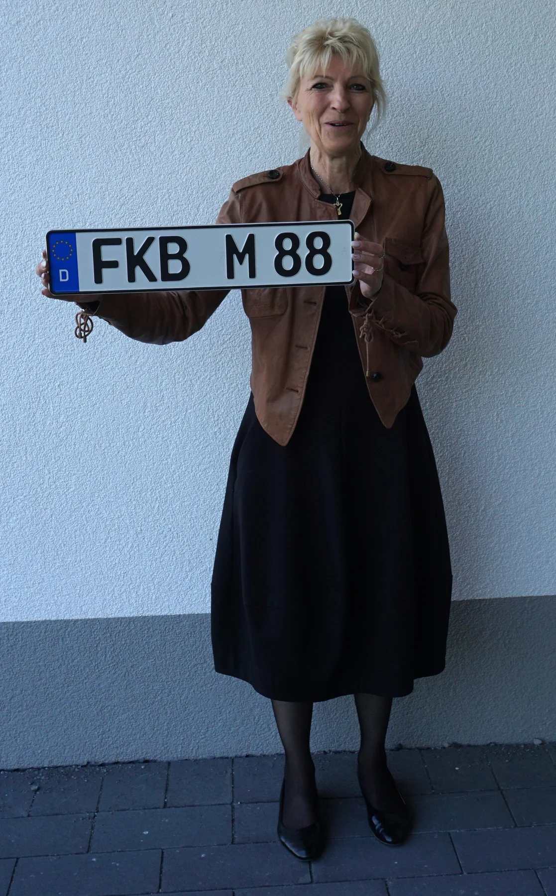 Meta Schneider hält das Kfz-Kennzeichen FKB M 88