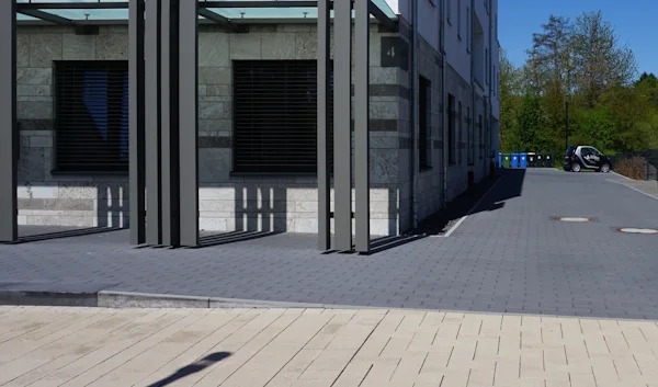 Gebäudeecke mit gepflastertem Weg zum hinteren Bereich