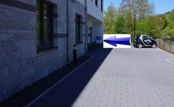 Detailansicht der Gebäudeseite mit Pfeil zum Eingang links